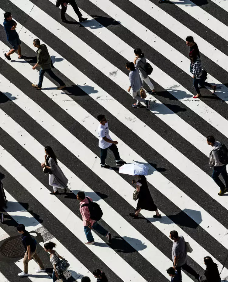 Vorlage_Hochkant Menschen gehen über eine schwarz-weiß gestreifte Fläche. Foto: Unsplash|Ryoji Iwata
